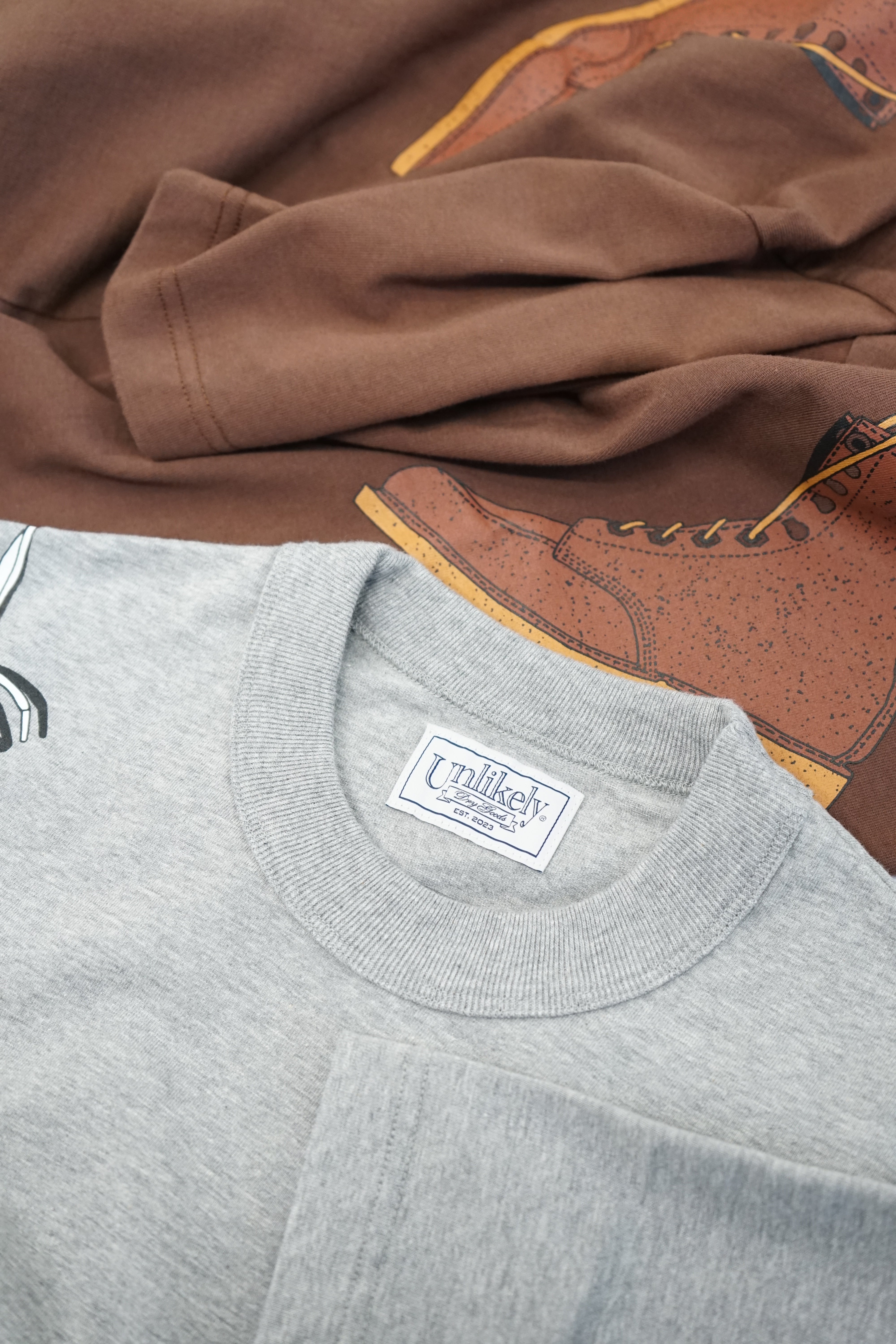 【7/25(土)発売】Unlikely Authentic Graphic Tee "BOOTS"